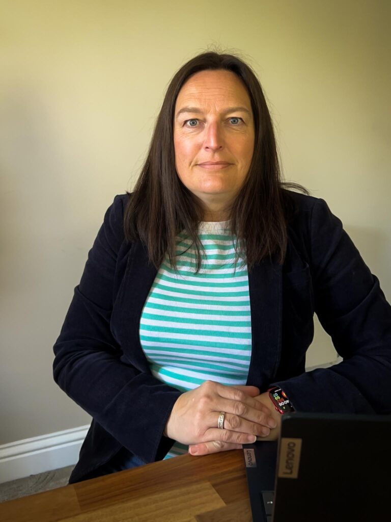 Kate Edwards of Kate Edwards HR Solutions sat a desk infront of laptop